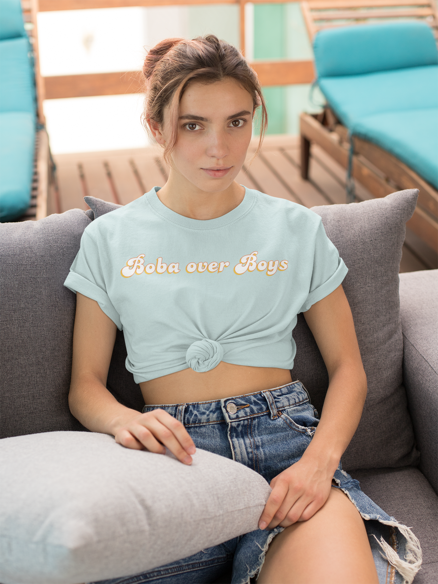 A woman wearing Boba over Boys boba shirt on the couch