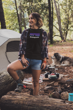 Woman wearing Black Bobagonia shirt standing against the log