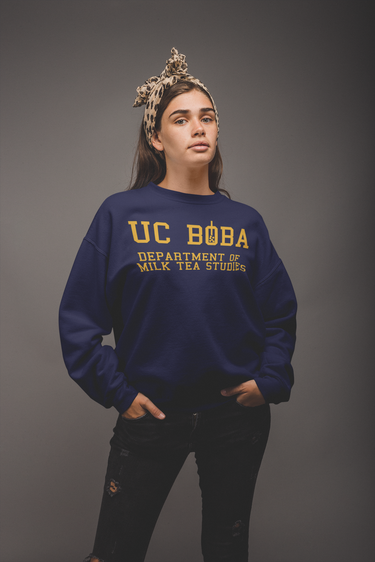 Woman wearing a UC Boba Sweater Against a Grey Background