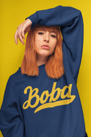 Woman wearing a Boba sweater posing against a yellow backgroun
