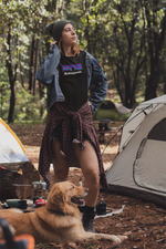 Woman wearing a black Bobagonia shirt with a golden retriever 