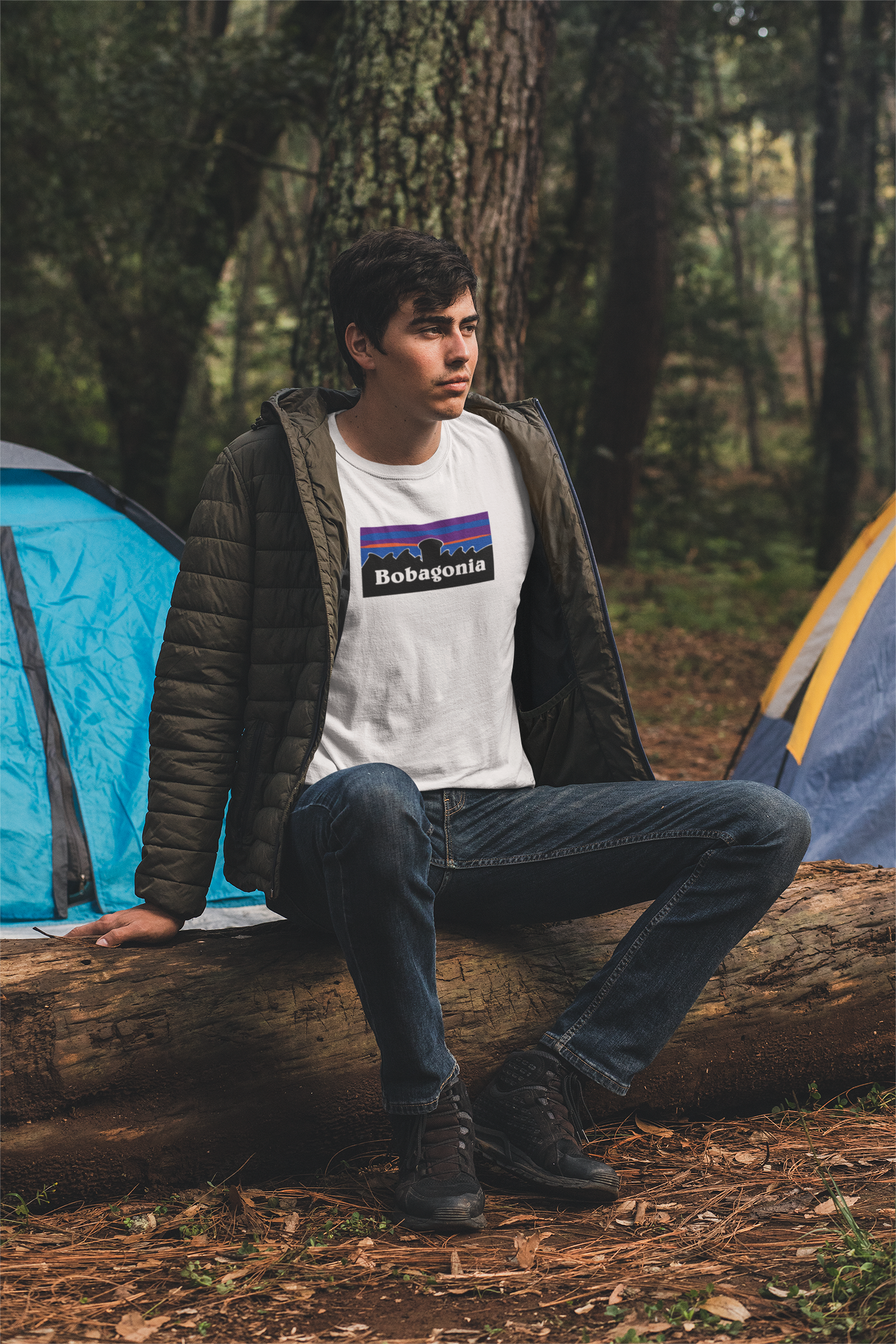 Man wearing a white bobagonia shirt sitting on a log